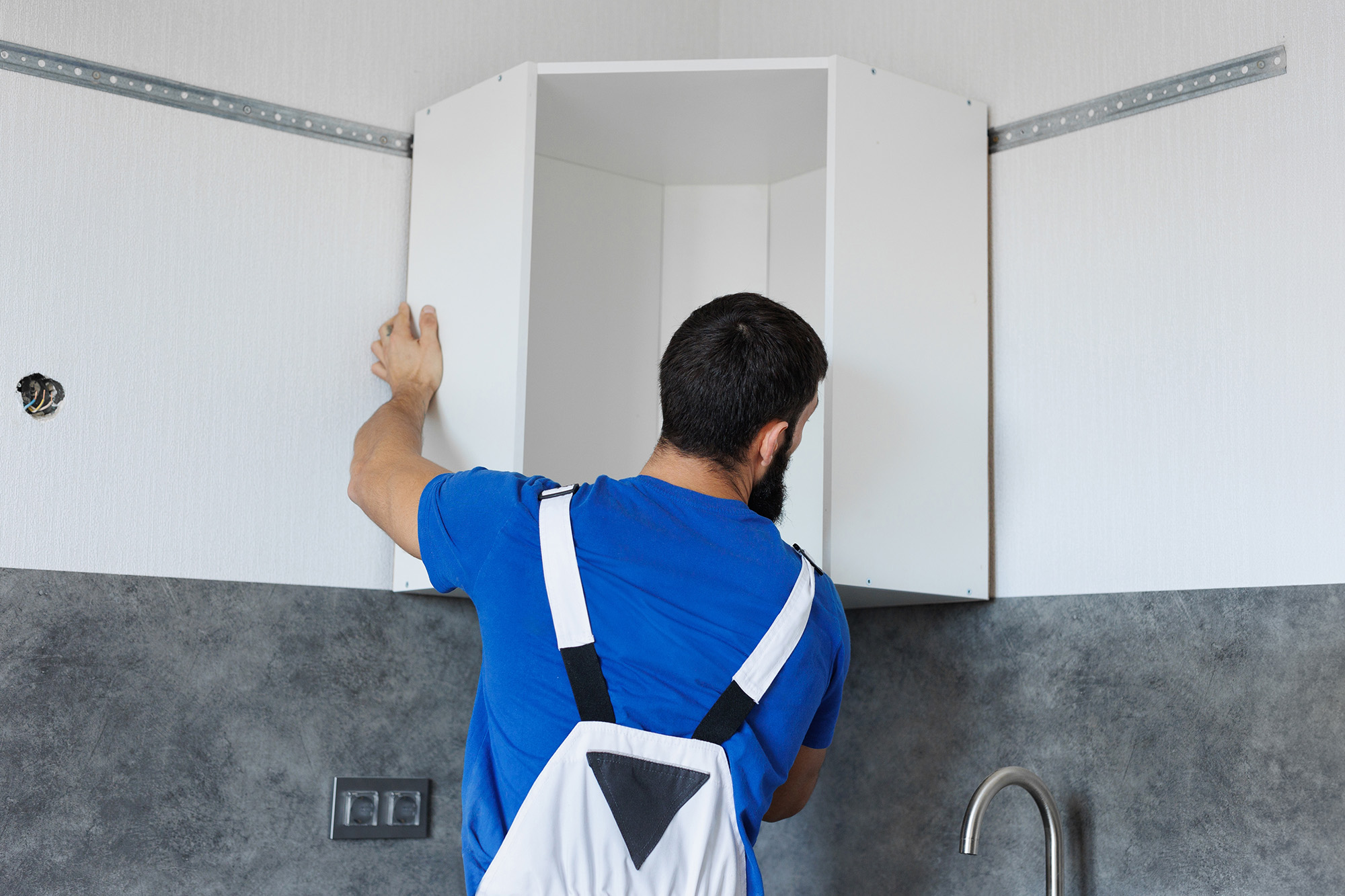 someone installing kitchen cabinets